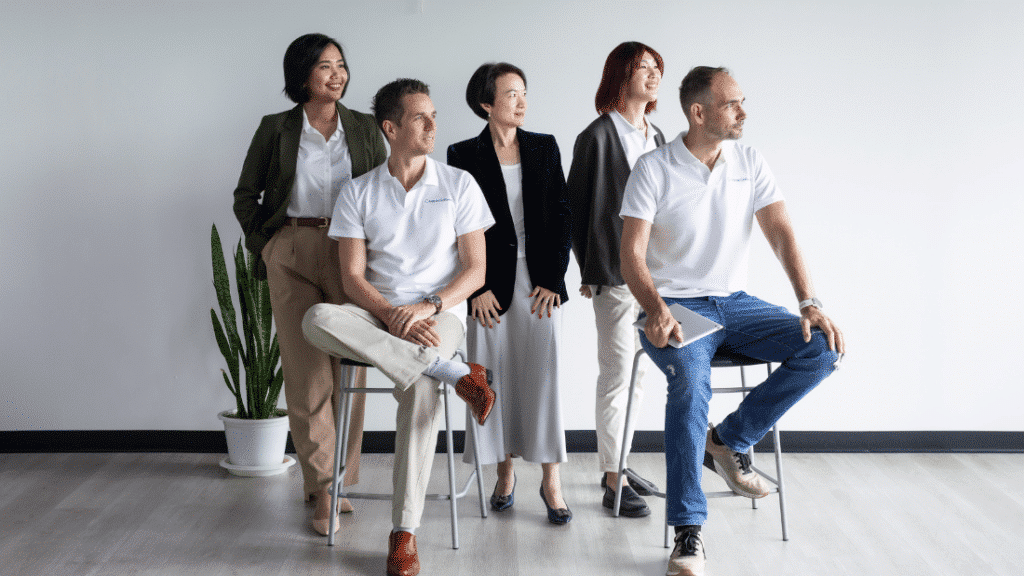 Group of business individuals on stools, collaborating on software development topics and project planning.